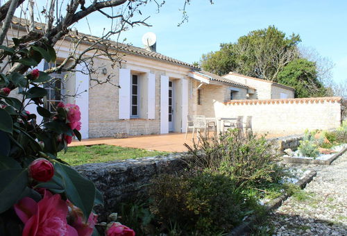 Jardin arboré, et maison en pierres apparentes à proximité de la mer